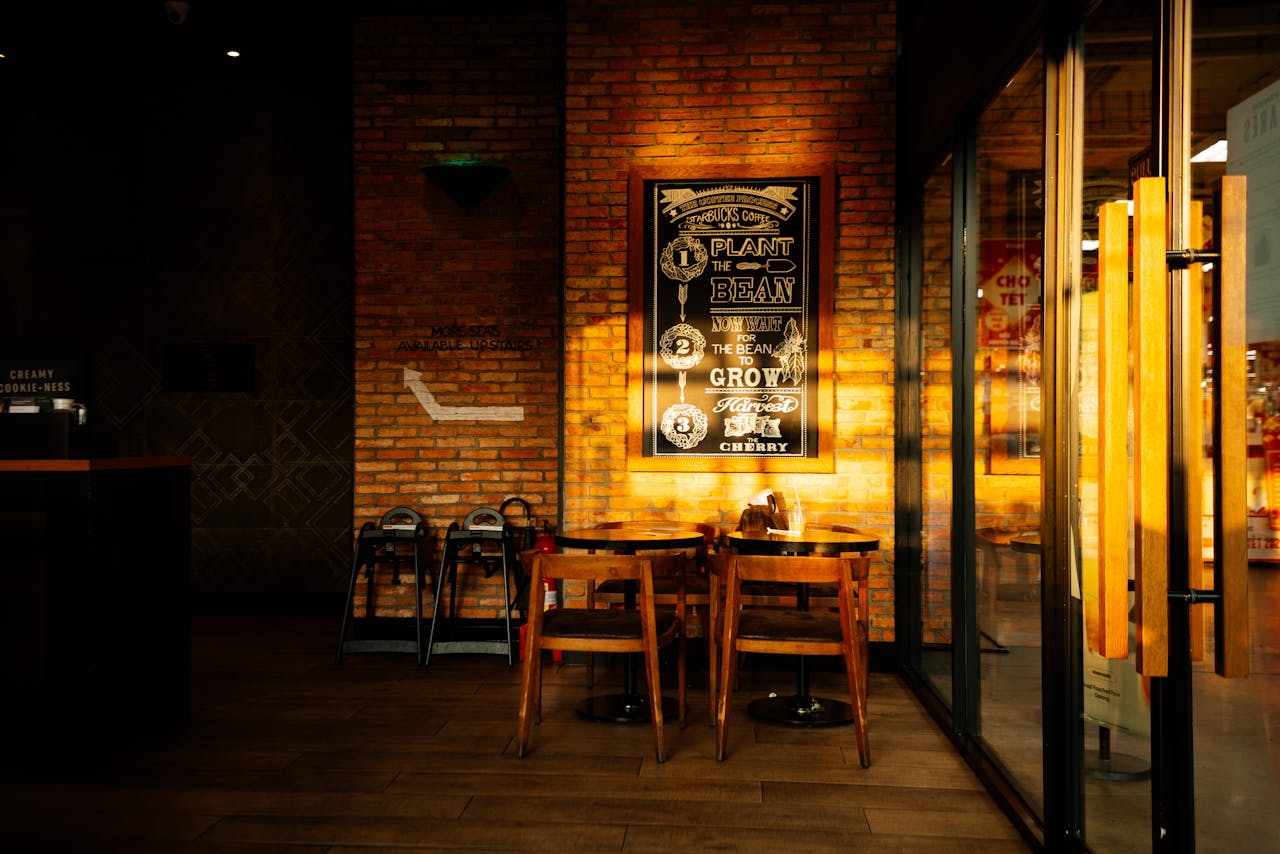 services-01 Warm and inviting coffee shop interior with sunlight and stylish design.